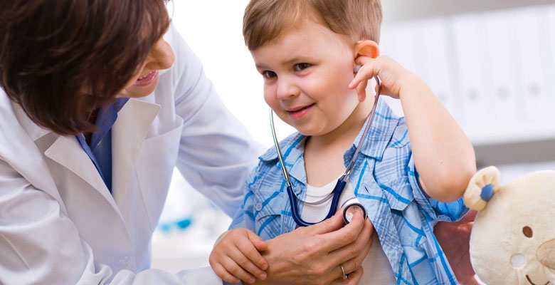 Revisión médica a niño pequeño, estetoscopio en el pecho.