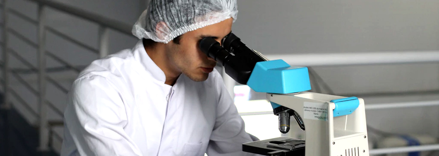 Medium close up de varón en laboratorio usando microscopio